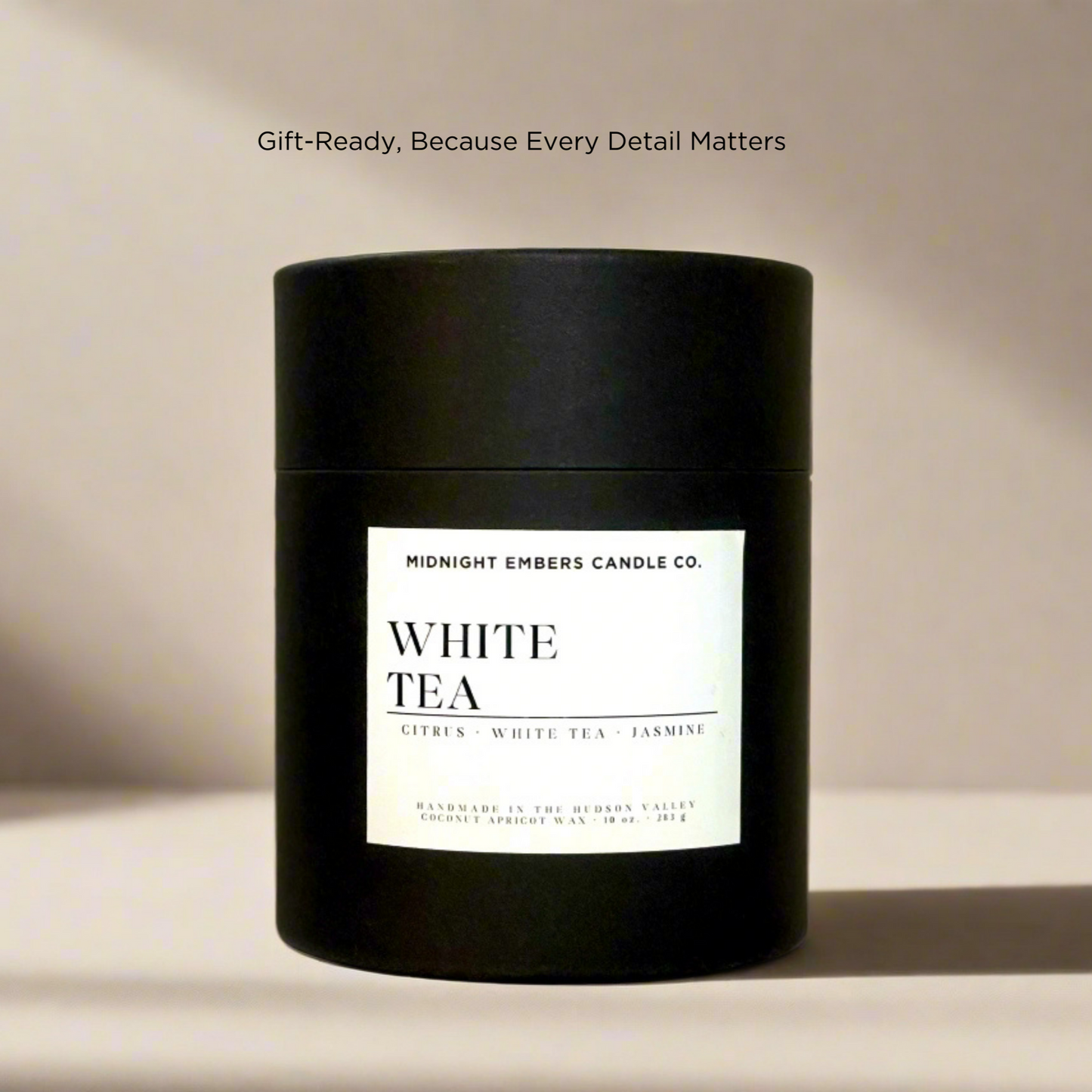 Black candle jar with white label on a beige background