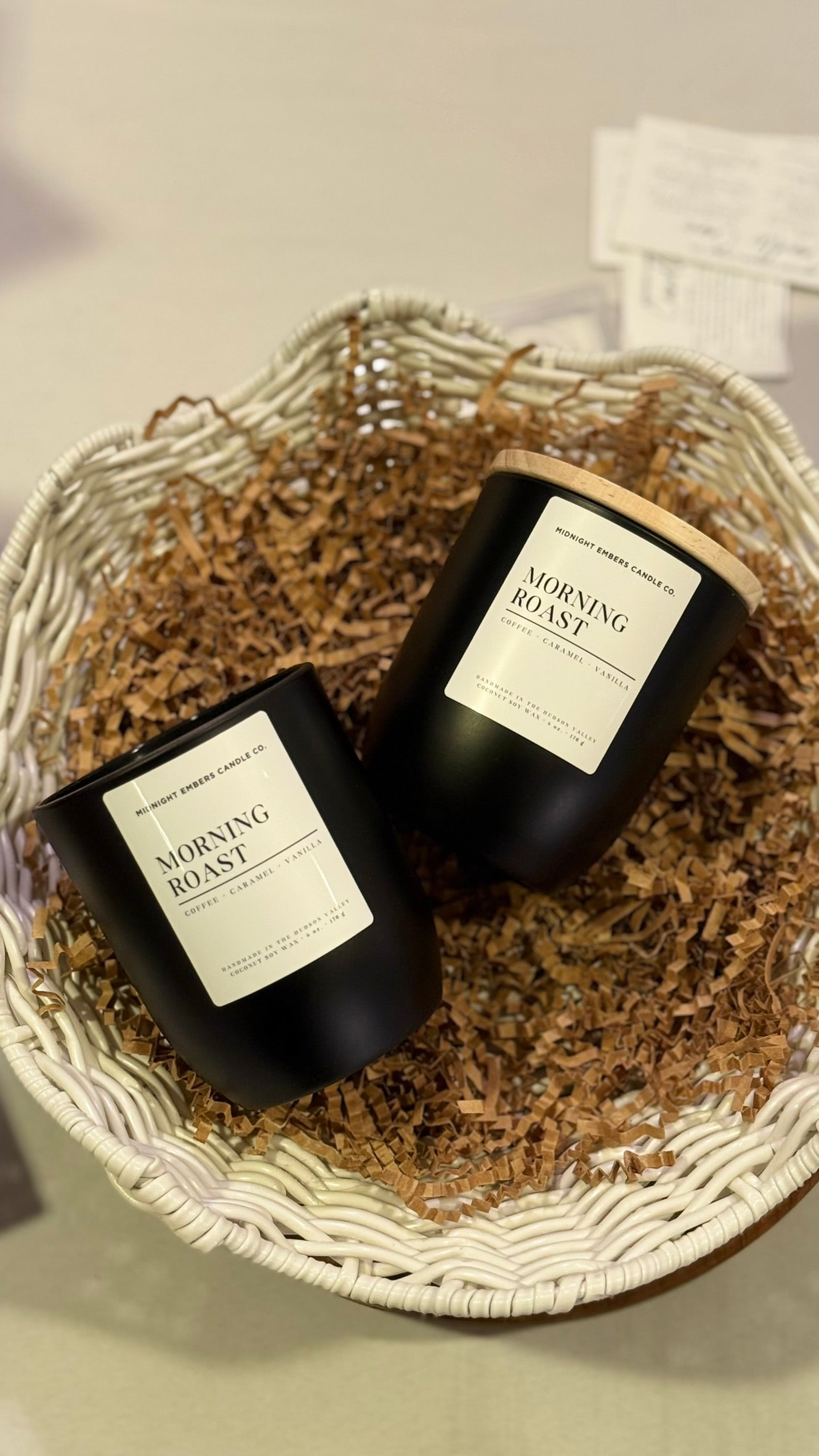 Two black candles labeled 'Morning Rustic' in a woven basket.