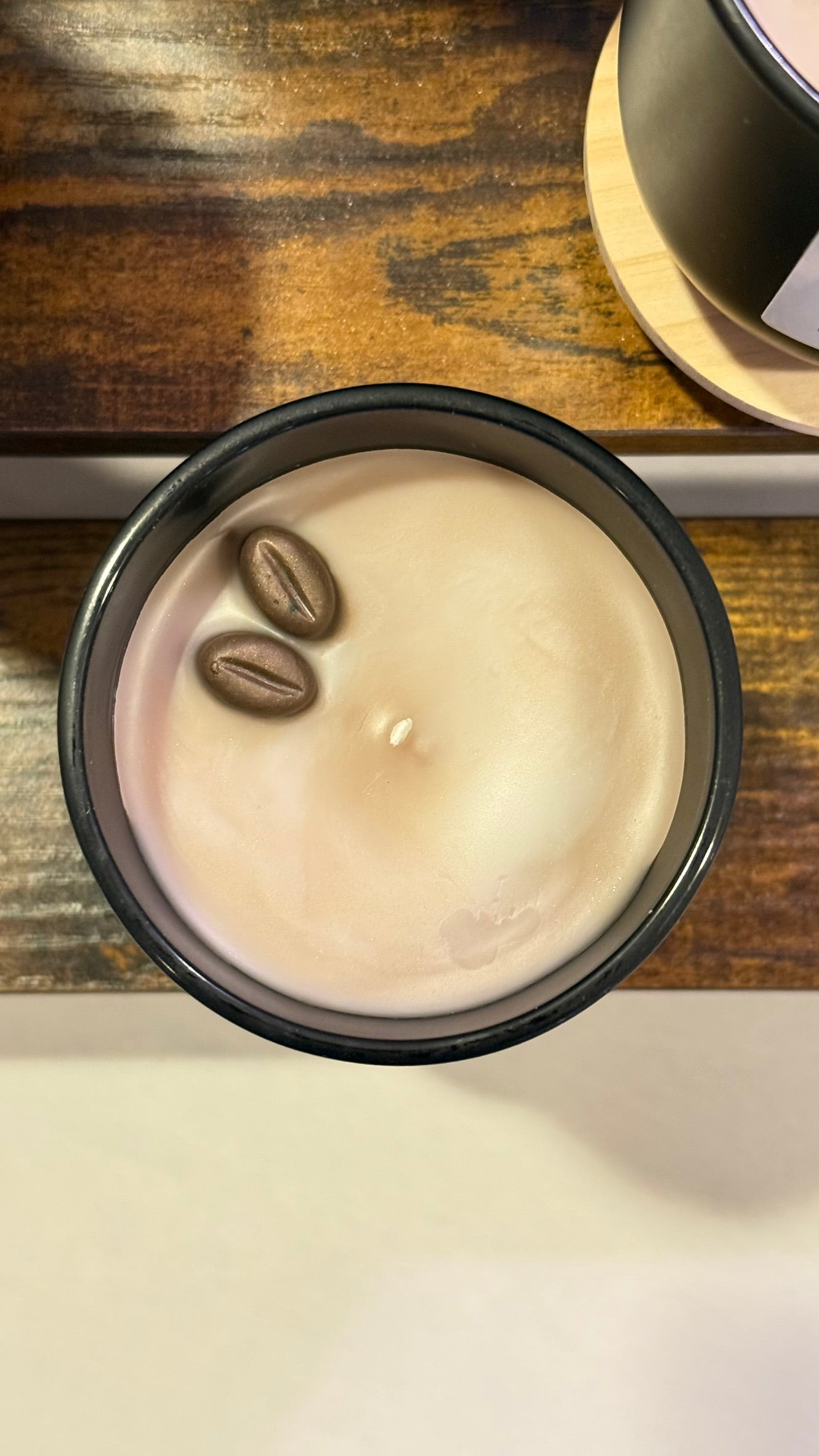 Candle with coffee beans on a wooden surface
