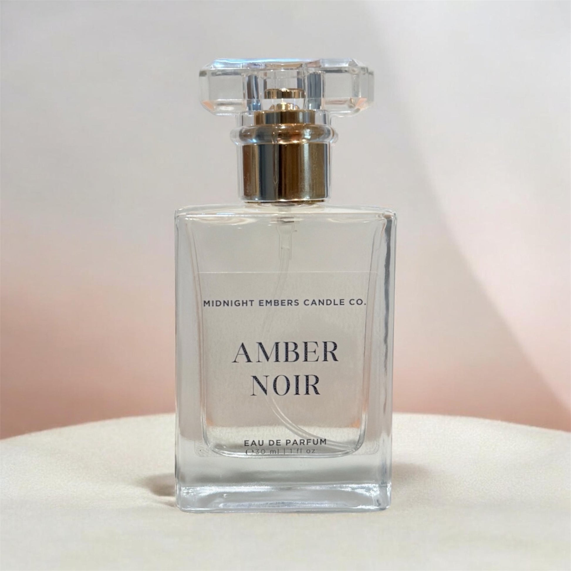 Perfume bottle labeled 'Amber Noir' by Midnight Embers Candle Co. on a light background