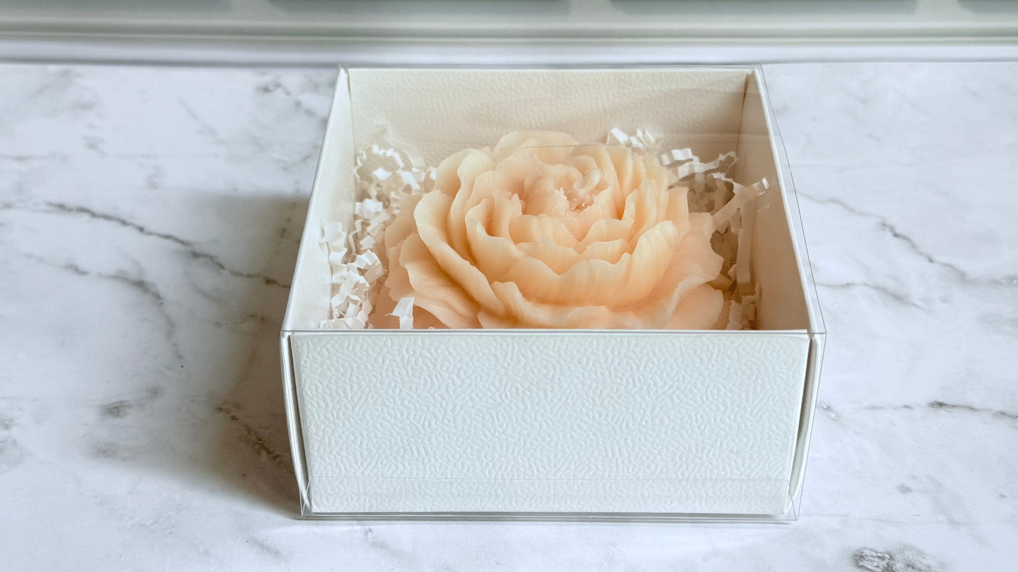 White box with a decorative peony on a marble surface