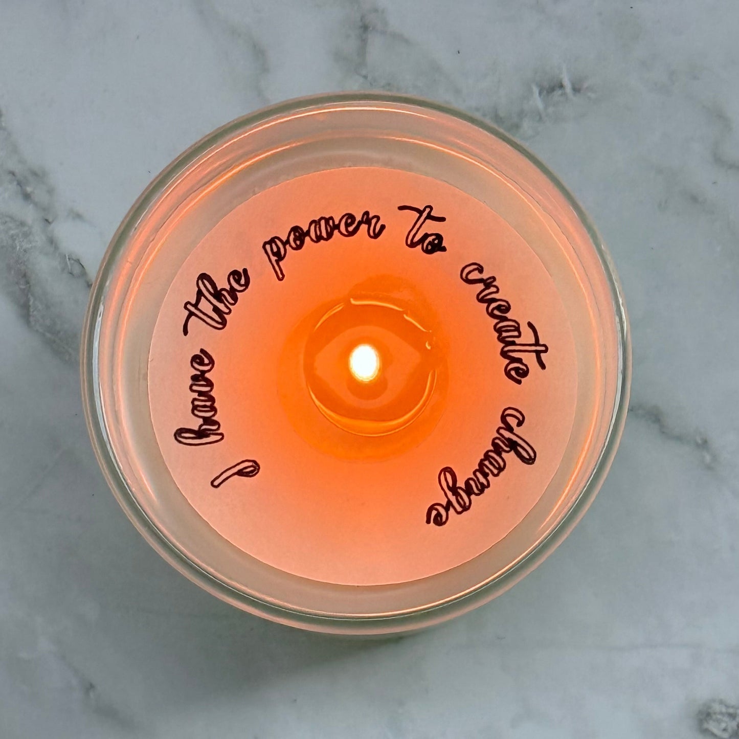 Candle with a motivational quote on a marble surface