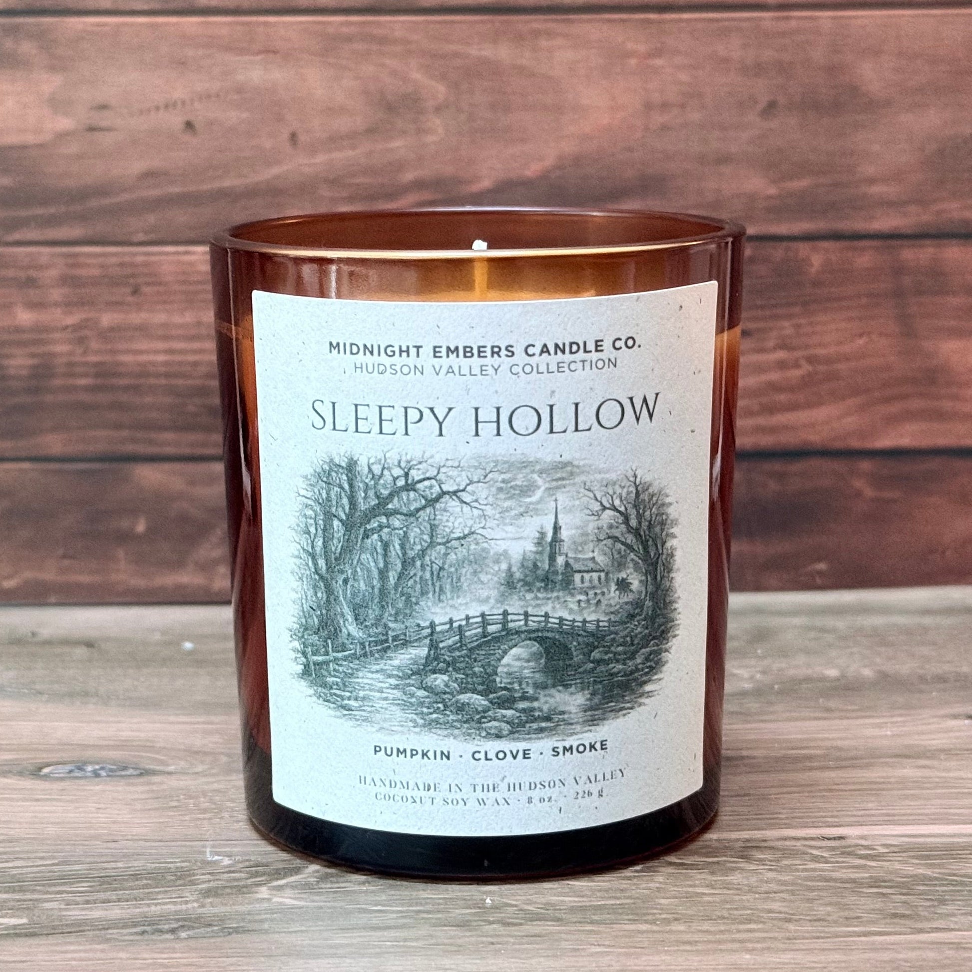 Candle with a label on a wooden surface