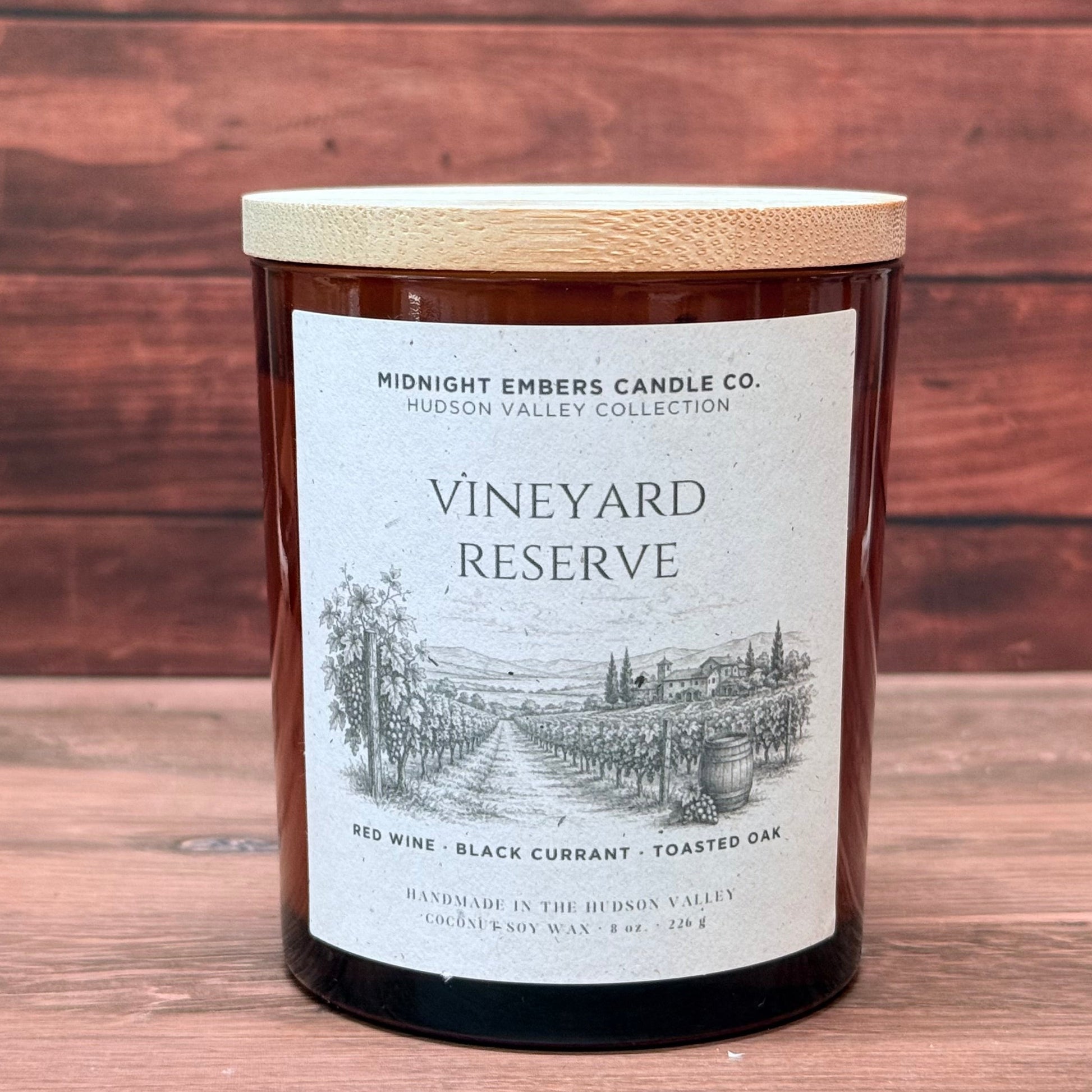 Candle labeled 'Vineyard Reserve' from Midnight Embers Candle Co. on a wooden background