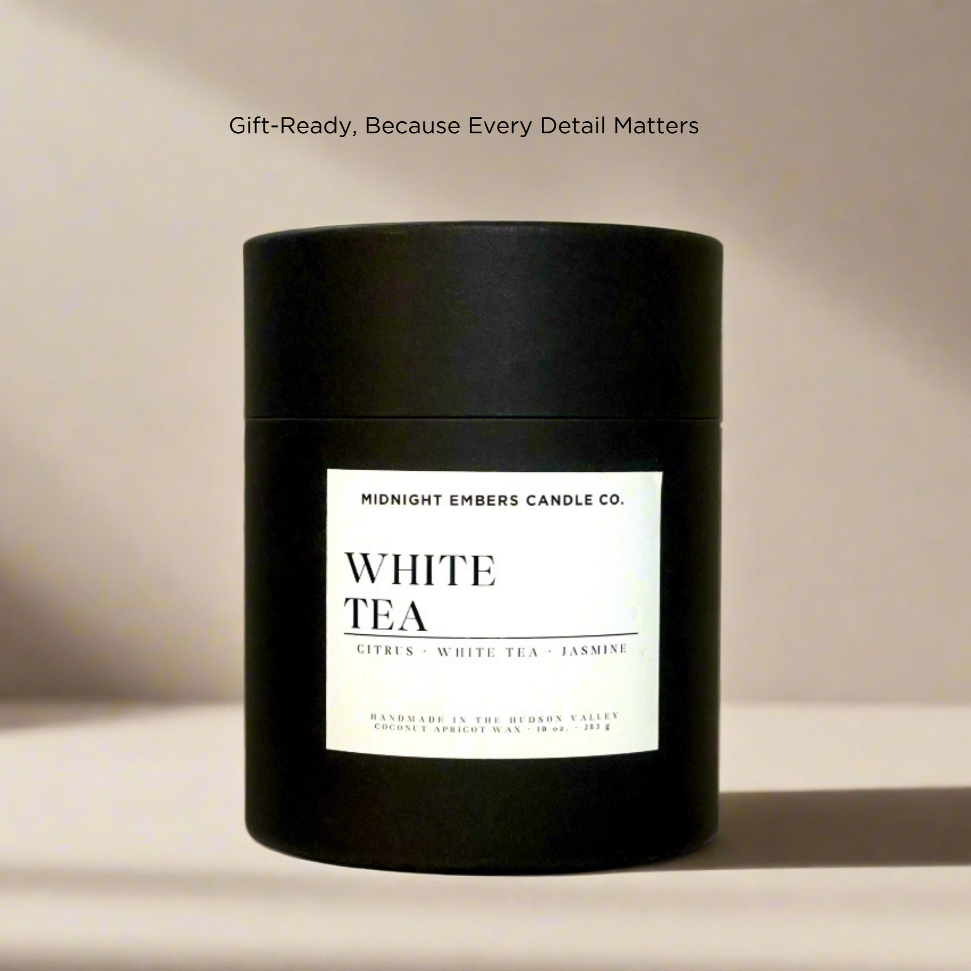 Black candle jar with white label on a beige background