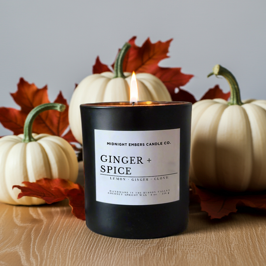 Ginger and spice candle with pumpkins and leaves on a wooden surface