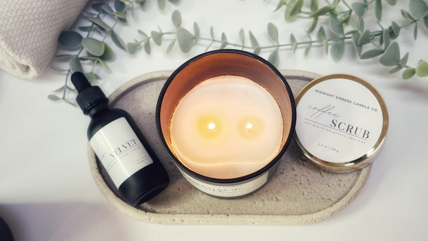 Candle, bottle, and jar on a tray with eucalyptus leaves in the background